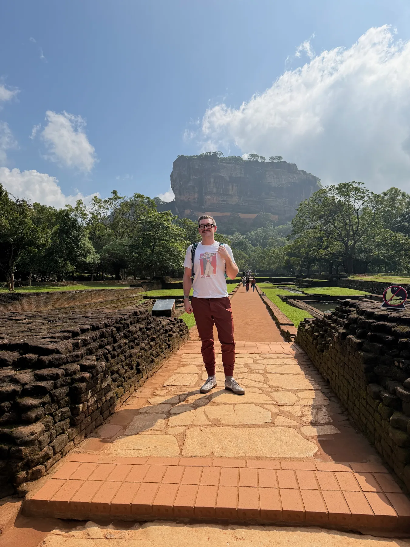 On the walkway through the water gardens with Sigiriya rock fortress rising behind