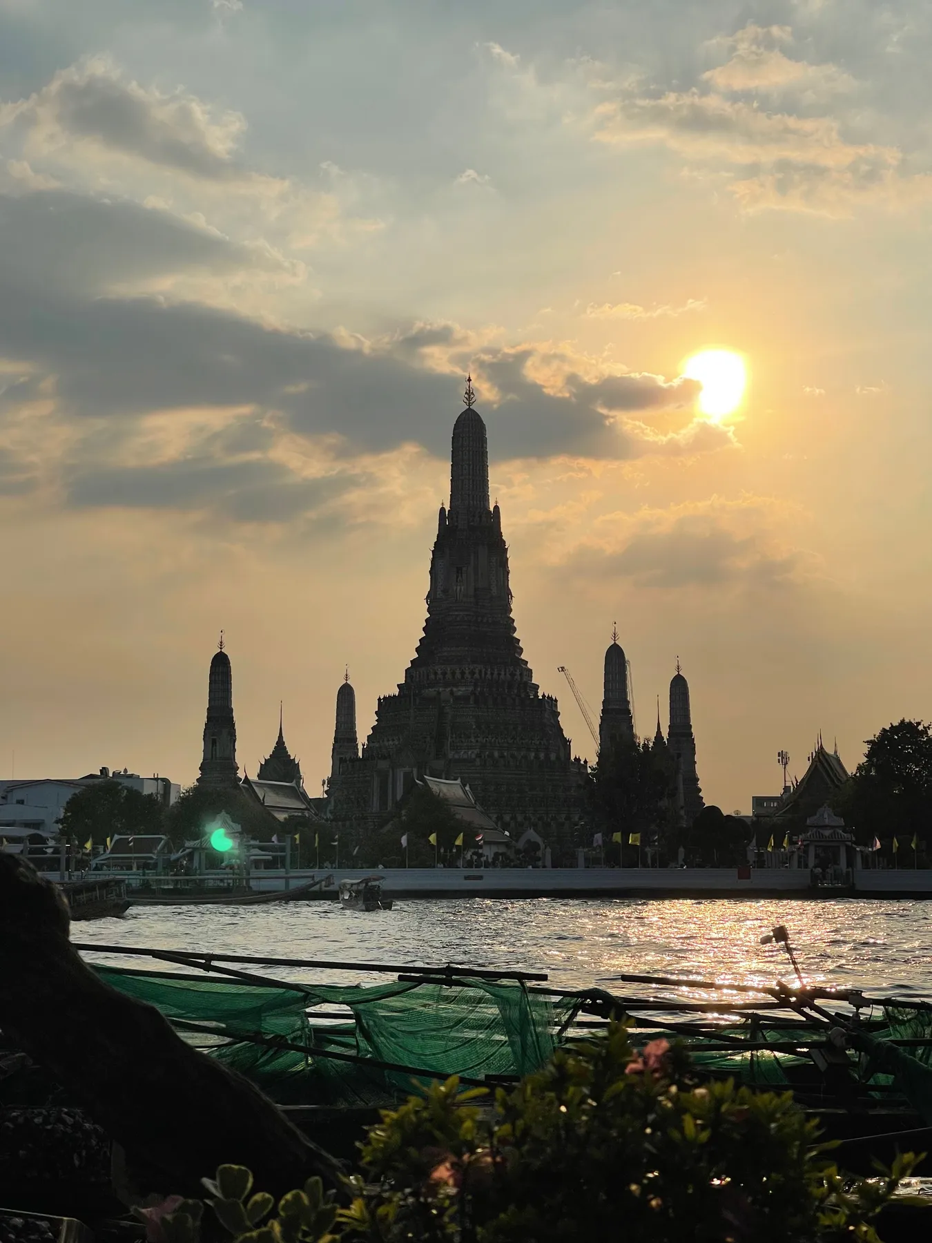 Wat Arun silhouetted against the sunset across the Chao Phraya River in Bangkok